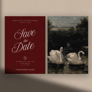 Pode incluir: Um conjunto de papelaria de casamento de duas peças com um cartão bordô profundo com texto branco Save the Date, Emilia & Jovan, Lyon, France, ao lado de um cartão com uma pintura de paisagem escura de dois cisnes brancos num lago.
