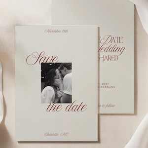 May include: Two rectangular cream-colored save the date cards with dark red serif and script typography. The front card features a black and white photograph of a couple, the text "Save the date", "November 18th", and "Charlotte, NC". The brand "Oakley&Co." is at the top.