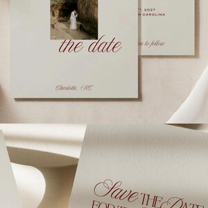 May include: Off-white save the date cards with dark red serif typography. One card features a square photograph of a couple near a large rock, with the text "Save the date", "November 18th", and "Charlotte, NC". Another card reads "Save the date for the wedding of Becca & Jared, November 18th, 2027, Charlotte, North Carolina, formal invitation to follow".