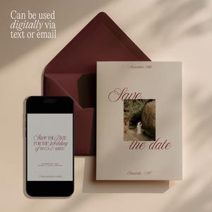 May include: A cream-colored Save the Date card with dark red serif text and a central photograph of a person in a white dress, paired with a matching dark red envelope and a smartphone displaying the same wedding announcement text.