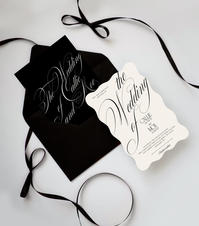K&ouml;nnte beinhalten: Ein schwarzer Umschlag mit einer schwarzen Karte mit wei&szlig;er Kalligrafie, die The Wedding of Callie and Moe liest, neben einer cremefarbenen, gewellten Hochzeitseinladung mit schwarzem Text und einem schwarzen Band, das um das Set gebunden ist.