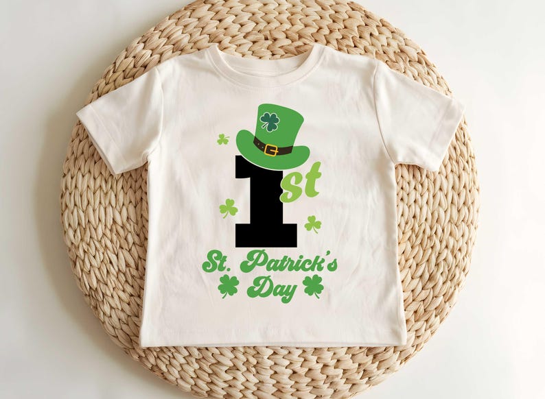May include: White t-shirt with a green shamrock hat, a black number one, and the text "1st St. Patrick's Day".
