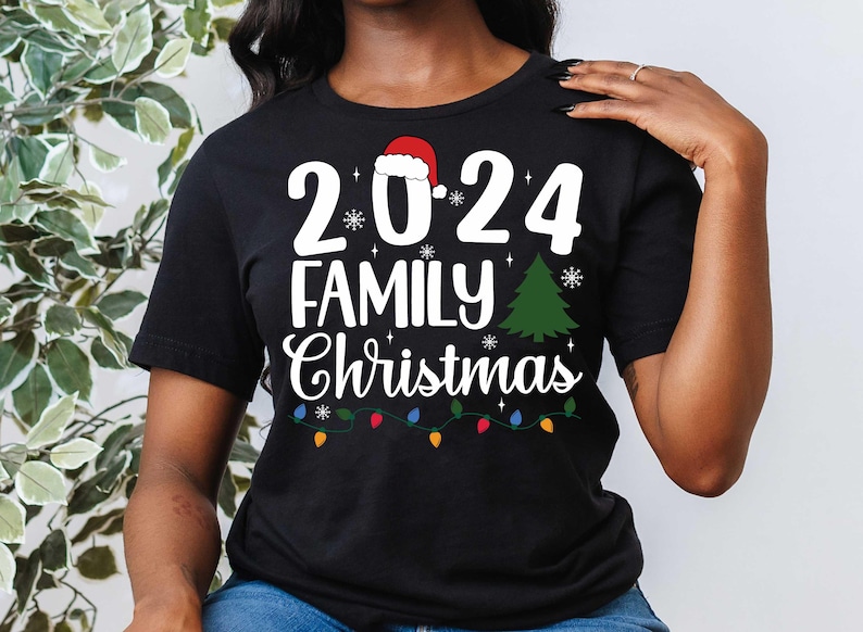 Pu&ograve; includere: Maglietta nera con testo bianco che recita "2024 Family Christmas" con un cappello di Babbo Natale rosso, un albero di Natale verde e luci di Natale colorate.