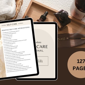Peut inclure: Une tablette num&eacute;rique affichant un journal de soins personnels avec 127 pages d'affirmations positives. La tablette est pos&eacute;e sur un plateau en bois avec des flacons d'huiles essentielles et de l'encens.