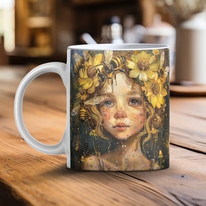 May include: White ceramic mug with a colorful illustration of a girl with a crown of flowers and bees. The girl has long brown hair and blue eyes. The background is a dark blue with gold accents.