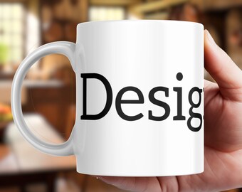 May include: White ceramic coffee mug with a black inscription that reads "Design".