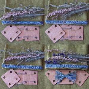 Può includere: Quattro quadrati di legno con dei fori, utilizzati per la tessitura. I quadrati sono disposti in due file di due. I quadrati sono su uno sfondo di tessuto verde con una fascia tessuta blu e bianca sopra. I quadrati vengono utilizzati per tessere una fascia a righe blu e bianca.