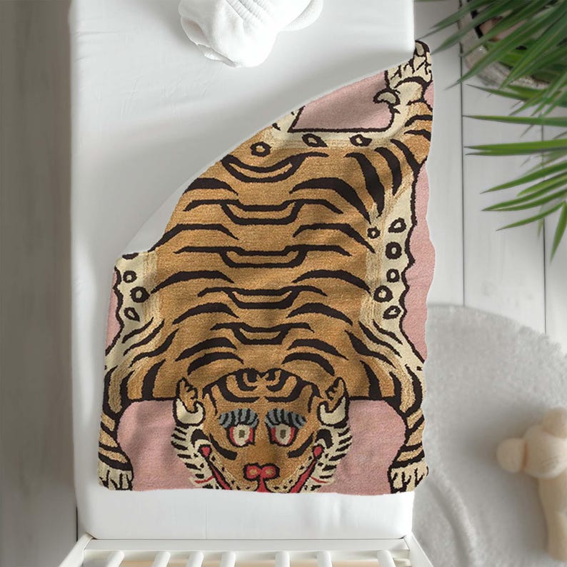 May include: A pink and brown tiger rug with a detailed design. The tiger is lying on its back with its paws in the air. The rug is ideal for a nursery or child's room.