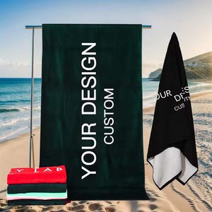 May include: Two beach towels with the text "YOUR DESIGN CUSTOM" printed on them. The towels are green and black.