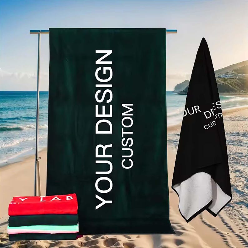 May include: Two beach towels with the text "YOUR DESIGN CUSTOM" printed on them. The towels are green and black.