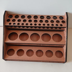 Peut inclure: Étagère en bois avec trois niveaux de découpes circulaires, idéale pour ranger et exposer de petits objets comme des flacons de peinture ou des huiles essentielles.