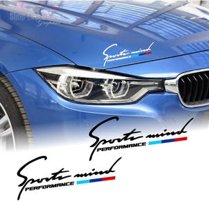 Pode incluir: Dois adesivos de vinil preto e branco com o texto "Sport mind Performance" e uma faixa azul, vermelha e branca. Os adesivos são mostrados em um carro azul.
