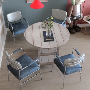 Puede incluir: Una mesa redonda de madera con un acabado blanqueado y cuatro sillas. Las sillas tienen un patrón de cuadros blanco y negro y están hechas de metal. Hay un jarrón con flores en el centro de la mesa.