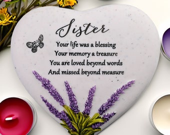 Può includere: Lapide a forma di cuore con la scritta "Sister". Presenta una farfalla, rametti di lavanda e la scritta: "Your life was a blessing, Your memory a treasure, You are loved beyond words, And missed beyond measure."