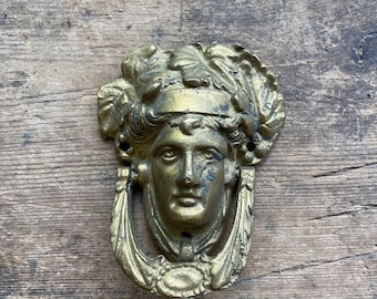 Aldaba de puerta antigua victoriana de latón adornado con un rostro de mujer teñido de oro, herrajes vintage de finales del siglo XIX, detalles únicos de decoración para el hogar al aire libre