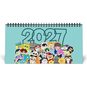 May include: A horizontal spiral-bound desk calendar with a light blue background. The year 2027 is printed in large dark teal numbers at the top. Below the text is a dense, colorful collection of various cartoon animal characters and creatures.