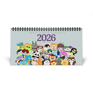 Puede incluir: Calendario encuadernado en espiral con una cubierta azul claro con el texto "GMMTV COUPLE CALENDAR" y el año "2026" en morado. La portada está decorada con una colorida variedad de personajes de dibujos animados.