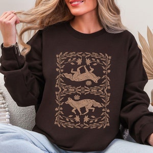 symmetrical fox linocut style in brown on the front of a sweatshirt