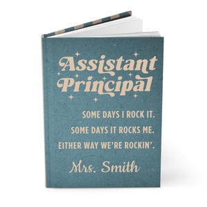 May include: A teal notebook with the words "Assistant Principal" in a vintage font. The notebook also includes the phrases "Some days I rock it. Some days it rocks me. Either way we're rockin'. Mrs. Smith."