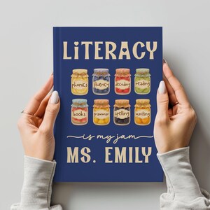 May include: A navy blue notebook with the word "LITERACY" in large, cream-colored letters. Below, eight jars are illustrated, each labeled with a literacy concept. The text "is my jam MS. EMILY" is written in a script font.