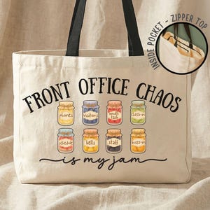 May include: Cream-colored tote bag with black handles, featuring the text "FRONT OFFICE CHAOS is my jam." The design includes colorful jars labeled with office-related terms like "phones" and "visitors." A small inset shows the bag's zipper top and inside pocket.