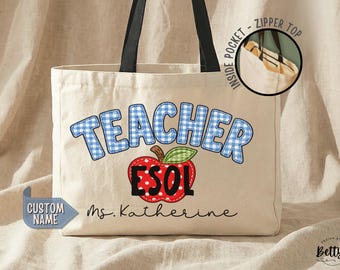 May include: A cream-colored canvas tote bag with black handles, featuring the blue gingham text TEACHER, a red apple graphic with a green leaf, the black text ESOL, and the name Ms. Katherine. An inset shows an inside pocket with a zipper top.