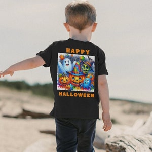 May include: Black t-shirt featuring a colorful Halloween graphic with a ghost, pumpkin, skull, and other characters. The words "HAPPY HALLOWEEN" are printed in orange above and below the graphic. The shirt is worn by a child.