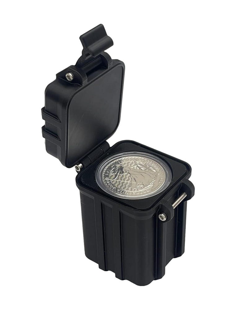 May include: A black plastic coin storage case with a hinged lid. The case is open and a silver coin is visible inside.
