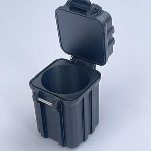 May include: A black plastic storage container with a hinged lid and a latch. The container is open and the lid is propped up.