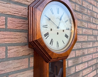 Westminster PUB clock with octagonal mahogany frame around the dial and 8-day pendulum movement.
