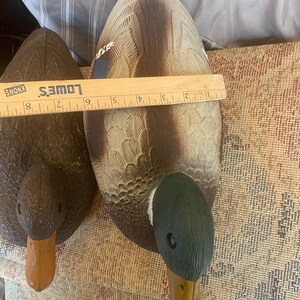 Top view of drake mallard duck decoy showing detailed feather texture across wings and back with blue accent patch and gray body tones, green head partially visible, vintage Flambeau molded plastic hunting decoy designed for floating use with weighted keel underside, rustic cabin lodge decor inspiration, lake house styling with sporting aesthetic, outdoorsman collectible with aged patina and paint wear, functional decoy that doubles as decorative wildlife accent