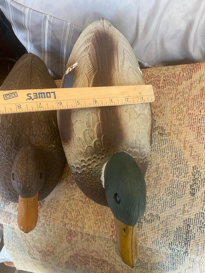 Top view of drake mallard duck decoy showing detailed feather texture across wings and back with blue accent patch and gray body tones, green head partially visible, vintage Flambeau molded plastic hunting decoy designed for floating use with weighted keel underside, rustic cabin lodge decor inspiration, lake house styling with sporting aesthetic, outdoorsman collectible with aged patina and paint wear, functional decoy that doubles as decorative wildlife accent