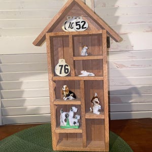 May include: A white ceramic mug with a black handle and the text "But First, Coffee" in a black, handwritten-style font. The mug is on a white surface.