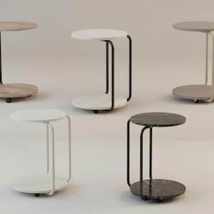 May include: A collection of five side tables with a modern design. Each table features a round top and base connected by a curved metal frame. The tops are made of different materials, including wood and marble. The tables are on wheels.