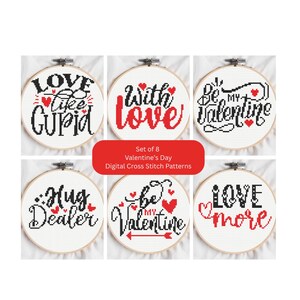 Op de afbeelding: Een set van acht digitale kruissteekpatronen voor Valentijnsdag, weergegeven in borduurringen. Elke ring toont een andere liefdesthema-zin in zwart en rood, zoals "Hug Dealer" en "Be My Valentine".