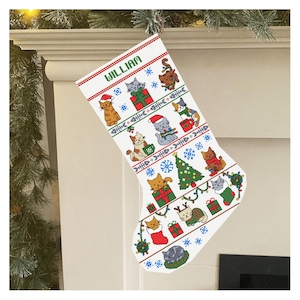 May include: White Christmas stocking featuring a pattern of various cats, Christmas trees, and gifts. The word "WILLIAM" is printed in green at the top. The stocking is decorated with red and green accents, and a fishbone design.