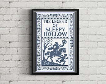 Op de afbeelding: Een ingelijst kruissteek borduurwerk met de tekst THE LEGEND OF SLEEPY HOLLOW in donkerblauw garen op een witte achtergrond. Het ontwerp bevat een silhouet van een ruiter zonder hoofd die een pompoen vasthoudt terwijl hij op een paard bij een boom rijdt.