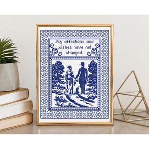 May include: A framed cross-stitch artwork in blue and white, depicting a couple walking on a path. The text "My affections and wishes have not changed" is at the top. The frame is gold.