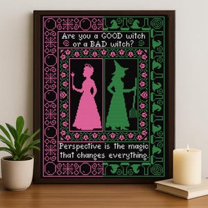 Könnte beinhalten: Gerahmte Kreuzstichkunst mit schwarzem Hintergrund, mit rosa und grünen Hexensilhouetten und Text. Der Text lautet: „Bist du eine GUTE Hexe oder eine SCHLECHTE Hexe?“ und „Perspektive ist die Magie, die alles verändert“.
