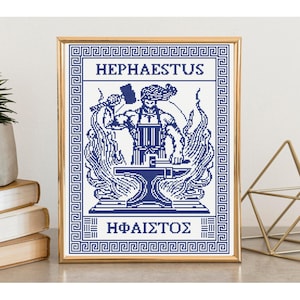 May include: A framed cross-stitch pattern in blue and white featuring a depiction of Hephaestus holding a hammer over an anvil, surrounded by flames. The text HEPHAESTUS and the Greek characters HΦAIΣTOΣ are printed above and below the central figure.