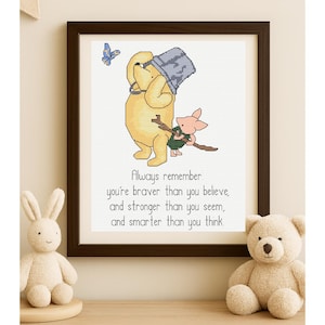 May include: Framed cross-stitch art featuring a yellow bear and a pink pig, with a blue butterfly. The text reads, "Always remember you're braver than you believe, and stronger than you seem, and smarter than you think."