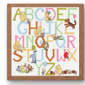 May include: Cross-stitch alphabet featuring Winnie the Pooh characters. The letters are in various colors, with each letter showcasing a different character. The artwork is framed in a wooden frame, perfect for a child's room or nursery.