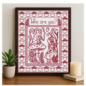Puede incluir: Obra de arte de punto de cruz en un marco marrón oscuro que representa una escena de Alicia en el país de las maravillas. El diseño está en hilo rojo sobre un fondo blanco, con el texto "Who are you?" en la parte superior.