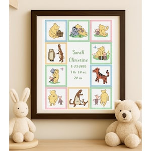 May include: A framed cross-stitch artwork featuring Winnie the Pooh characters. The artwork includes the name "Sarah Christine", birthdate, weight, and height of 50.8 cm. The frame is dark brown.