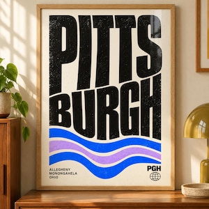 Peut inclure: Une affiche encadrée présentant le mot PITTSBURGH en grandes lettres capitales noires à l'aspect vieilli. Sous le texte, trois lignes ondulées horizontales en bleu et violet clair. Le texte ALLEGHENY MONONGAHELA OHIO et PGH avec une icône de globe.