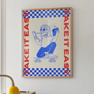 Op de afbeelding: Een blauwe en witte geruite rand omringt een witte achtergrond met de tekst "TAKE IT EASY" in rood aan de linker- en rechterkant. Een blauwe illustratie van een persoon met een zonnebril en een blauw shirt rijdt skateboard terwijl hij een boek leest.