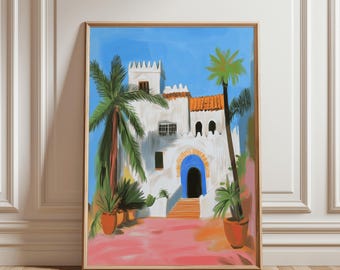 Puede incluir: Una impresión artística enmarcada representa un edificio blanco con una puerta arqueada azul y un tejado de tejas naranja, sobre un cielo azul brillante. Palmeras y plantas en macetas enmarcan el edificio, con un patio rosa y naranja.