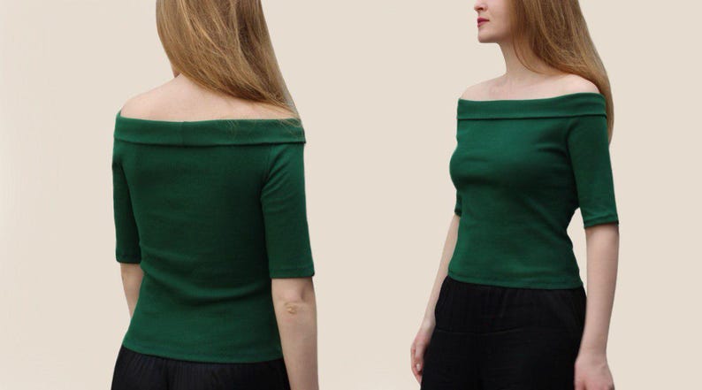 May include: A green off-the-shoulder top with short sleeves.