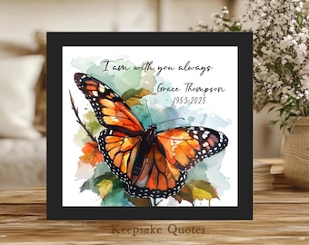 Könnte beinhalten: Gerahmter Druck mit einem Aquarell-Schmetterling mit orangefarbenen und schwarzen Flügeln. Das Kunstwerk enthält den Text "I am with you always" und den Namen "Grace Thompson 1953-2025". Der Rahmenboden lautet "Keepsake Quotes".