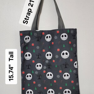 May include: A black tote bag with a repeating pattern of Jack Skellington faces, Christmas trees, snowflakes, and gift boxes. The bag is 15.74" tall and 13.78" wide, with a 21" long strap.